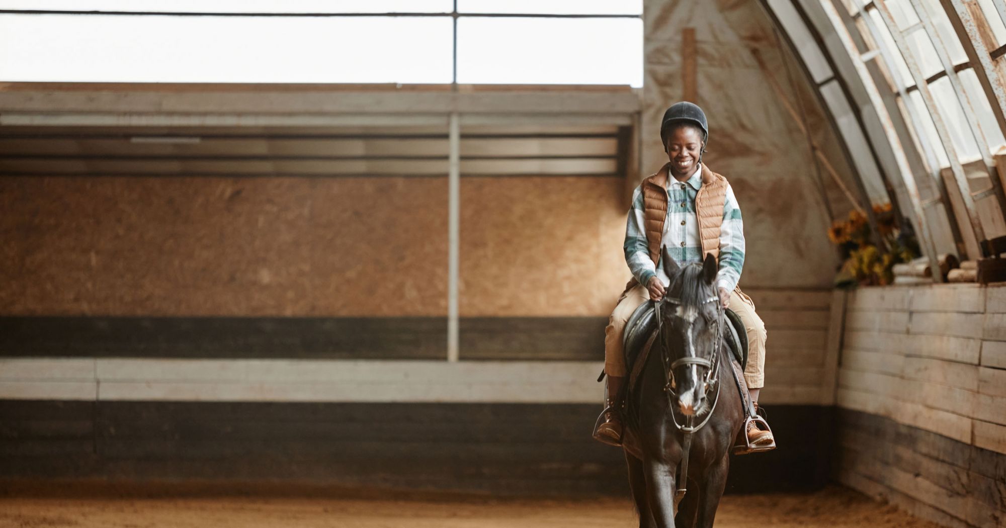 A horse is ridden indoors